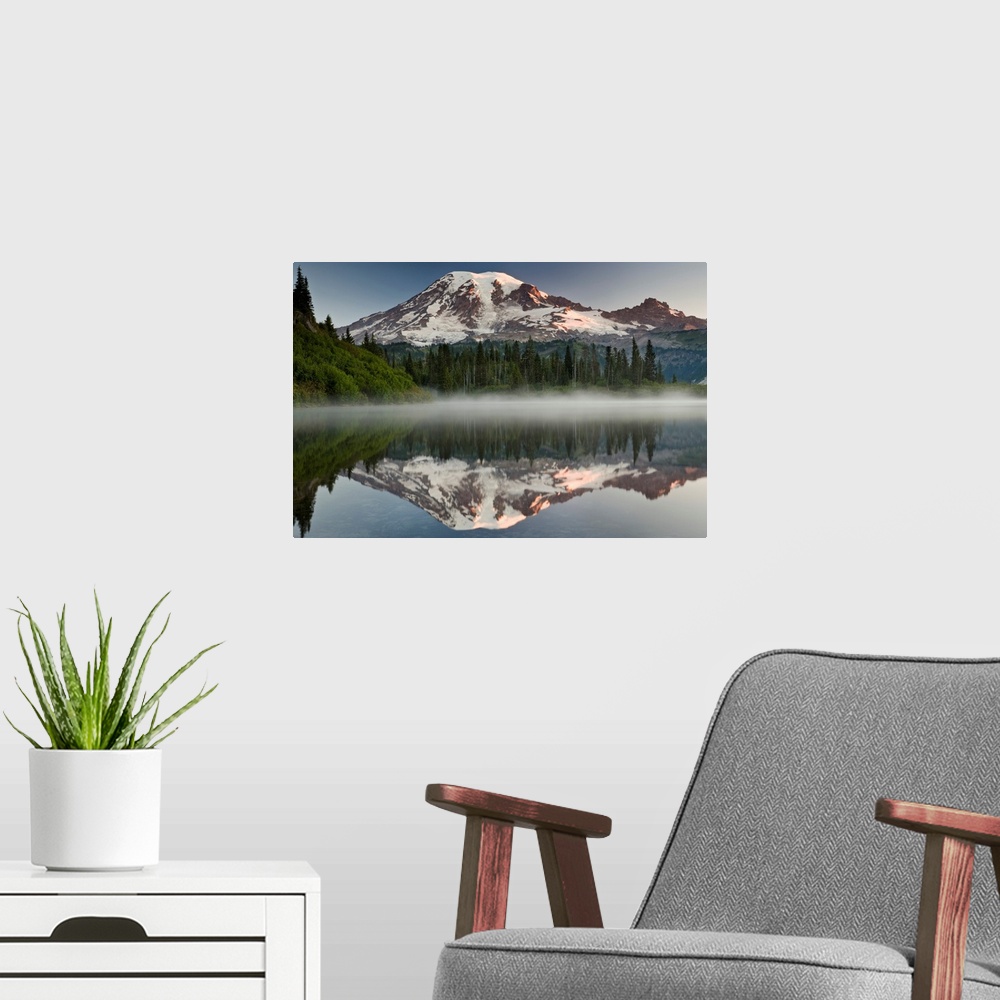 A modern room featuring Big photograph shows the great size of snow-covered Mount Rainier in the background reflecting ov...