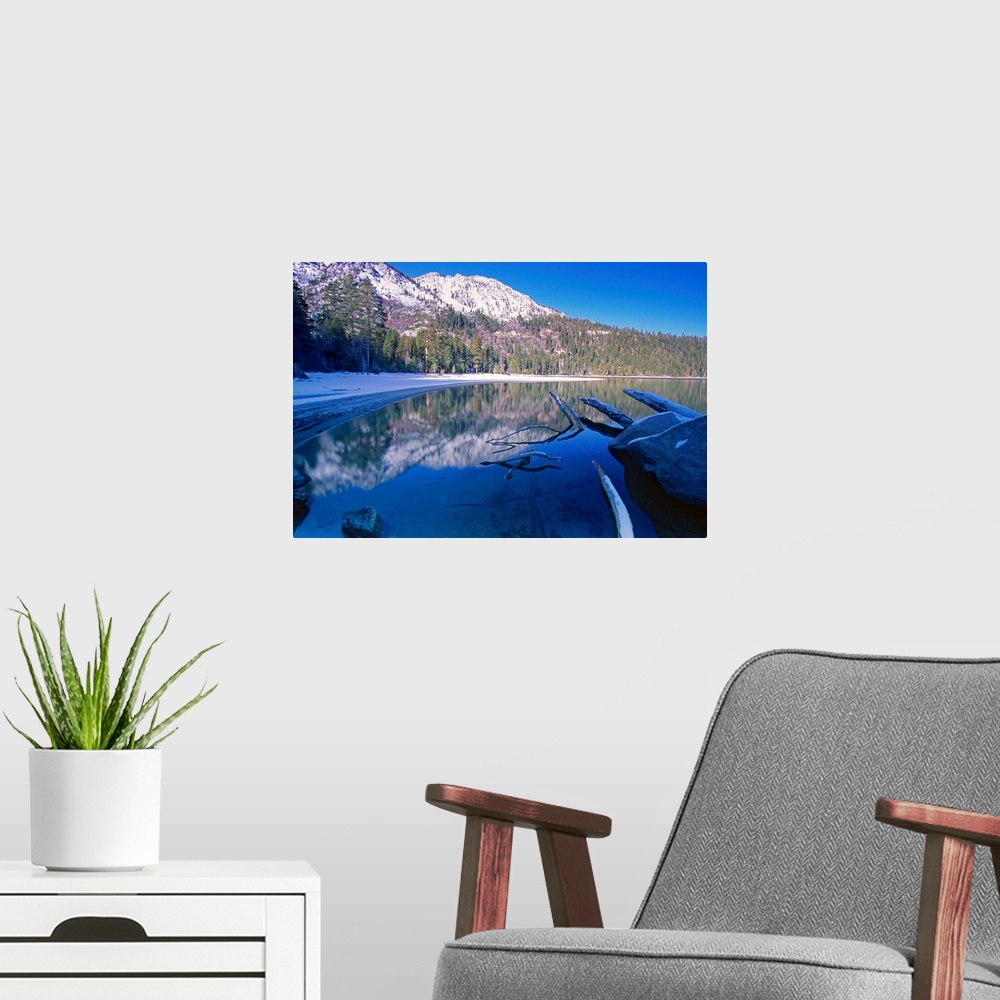 A modern room featuring Landscape, big photograph of the still waters of Emerald Bay at Lake Tahoe, California, surrounde...