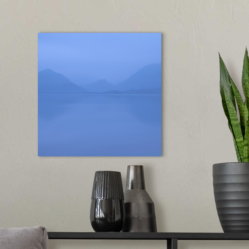 A modern room featuring Square photograph of a blue foggy lake with mountains in the background.
