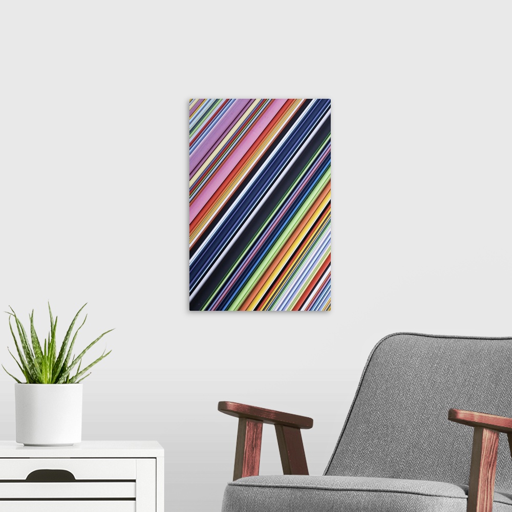 A modern room featuring A contemporary energetic rainbow hued abstract with diagonal lines of many shades of colour.