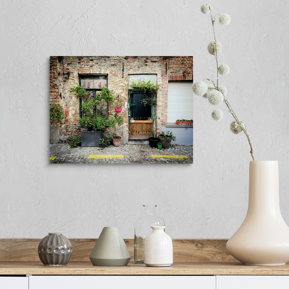 A farmhouse room featuring A photo of brick building covered in plants from a street view.