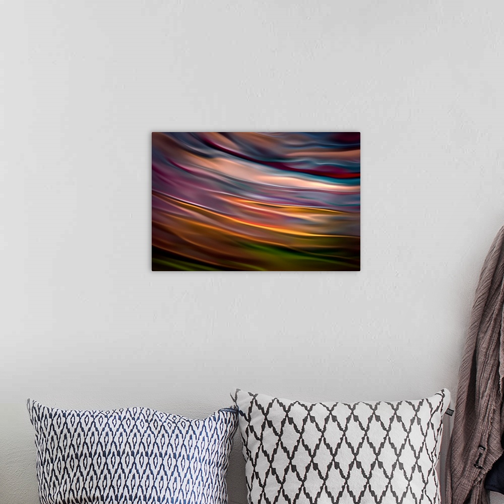A bohemian room featuring Abstract photograph in orange and blue shades resembling ocean waves.