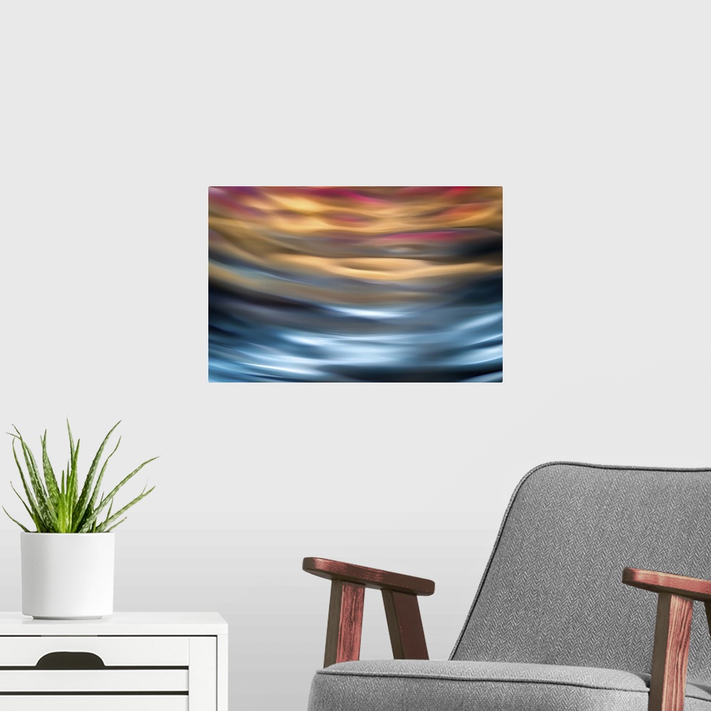 A modern room featuring Abstract photograph in orange and blue shades resembling ocean waves.