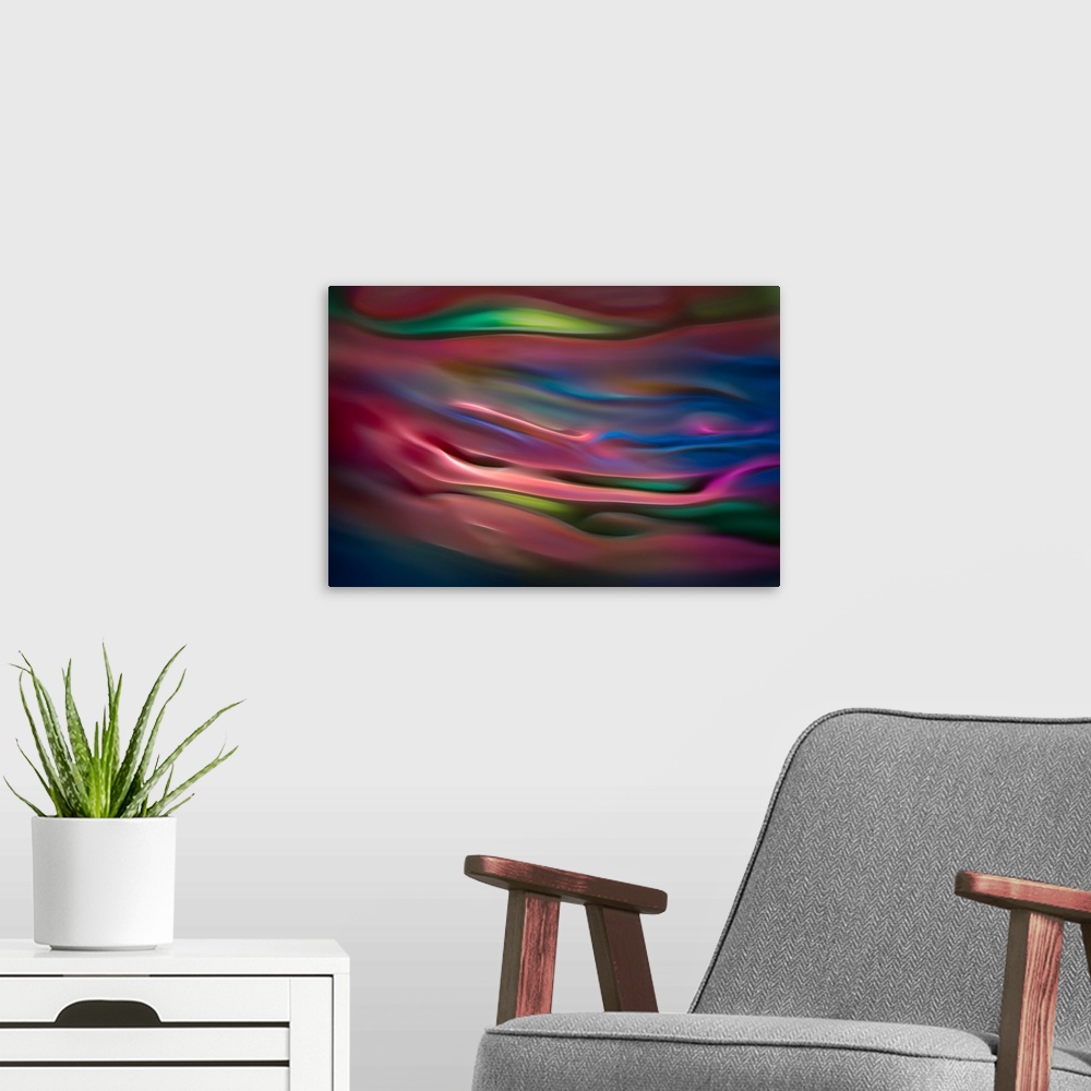 A modern room featuring Abstract photograph in pink and blue shades resembling ocean waves.