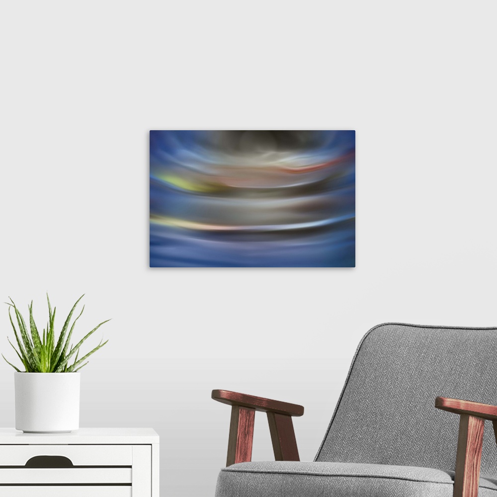 A modern room featuring Abstract photograph in grey and blue shades resembling ocean waves.
