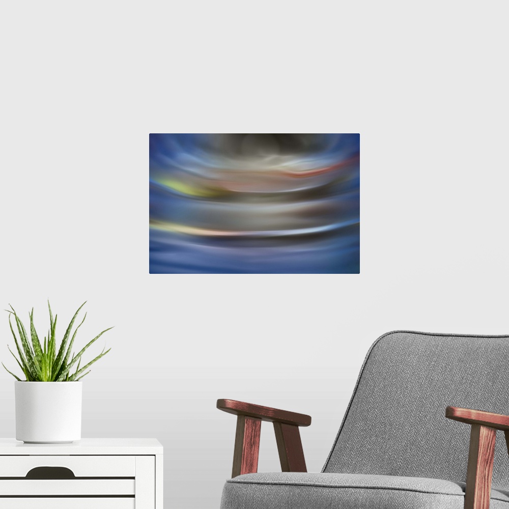 A modern room featuring Abstract photograph in grey and blue shades resembling ocean waves.