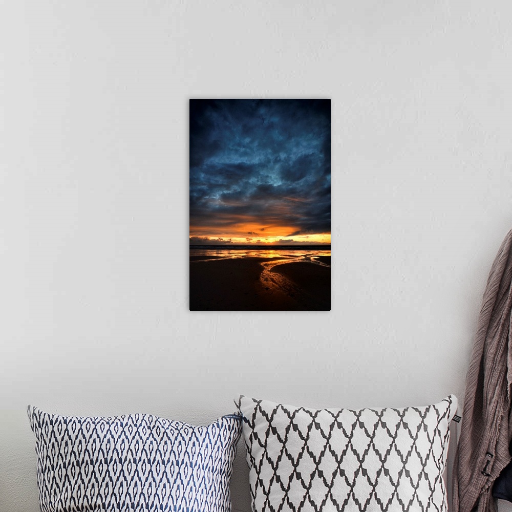 A bohemian room featuring Sunrise with orange and blue colors on a sand beach in France, vertical view.