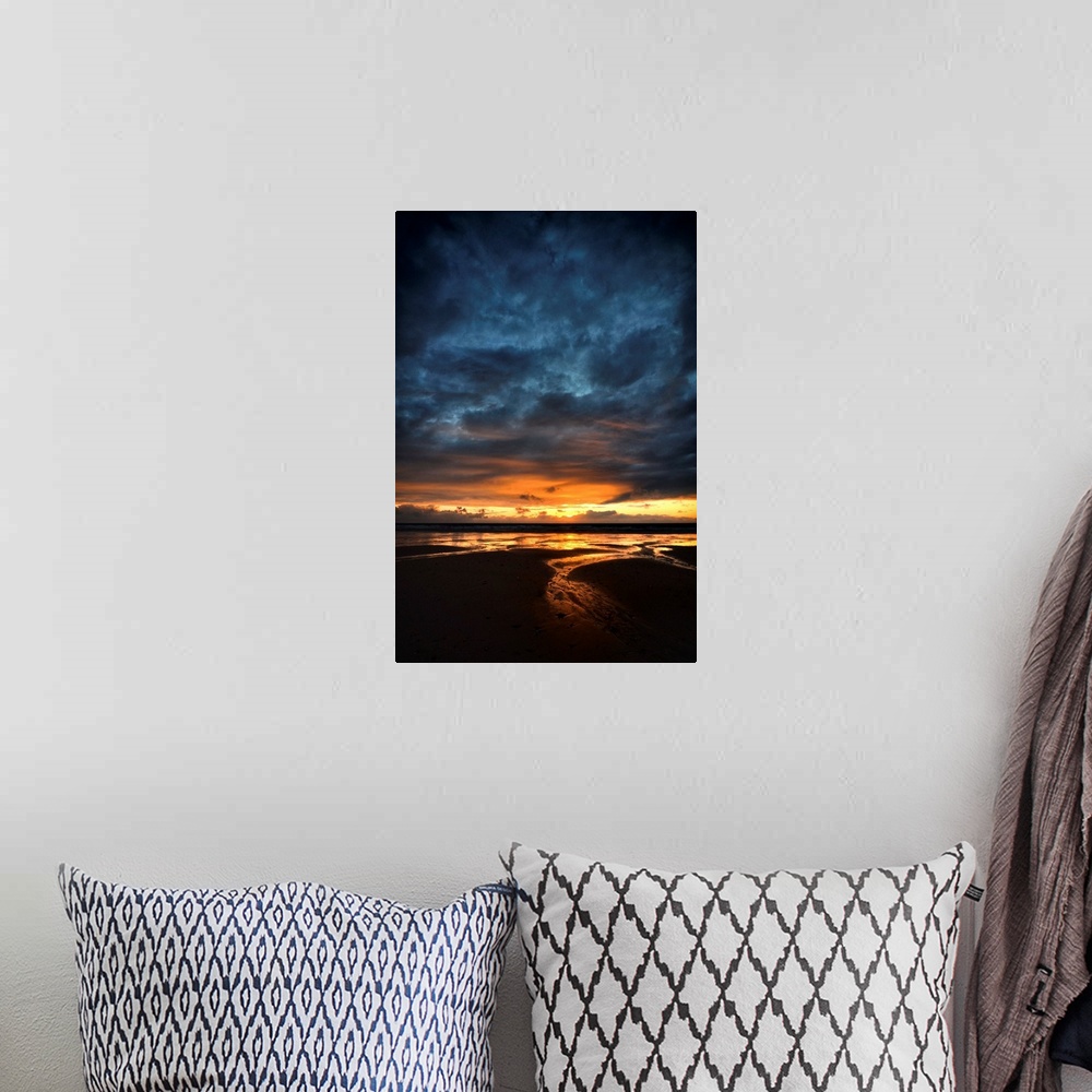 A bohemian room featuring Sunrise with orange and blue colors on a sand beach in France, vertical view.