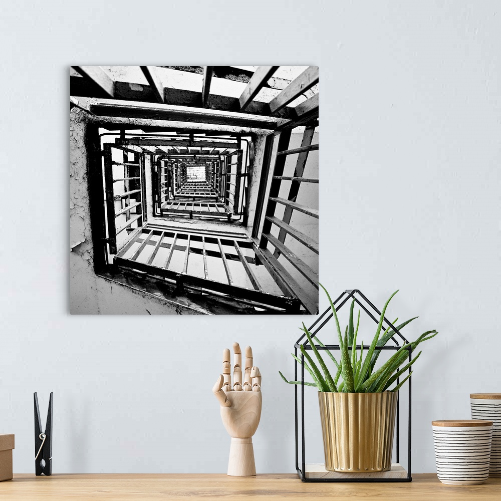 A bohemian room featuring A monochrome black and white square spiral staircase close-up.