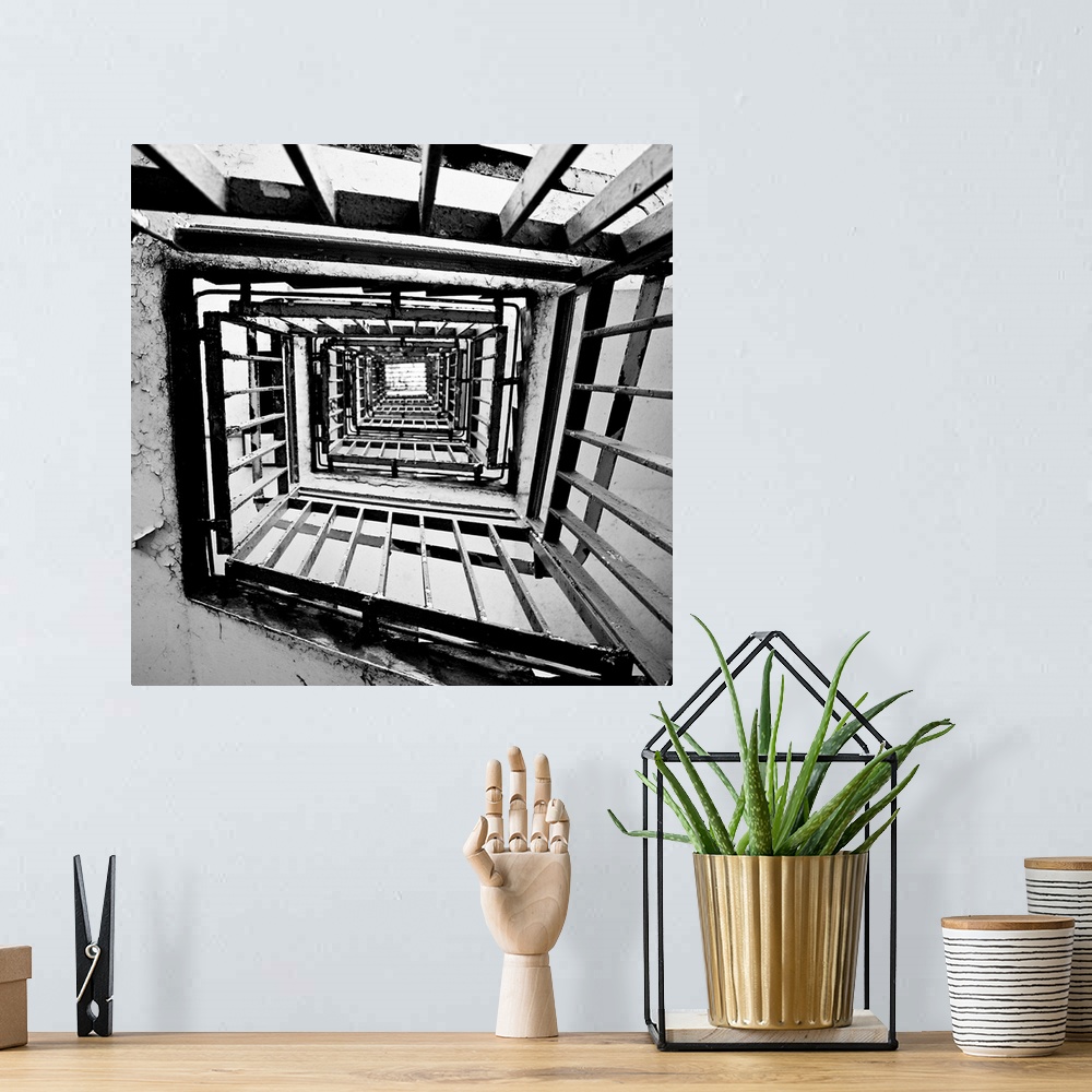 A bohemian room featuring A monochrome black and white square spiral staircase close-up.