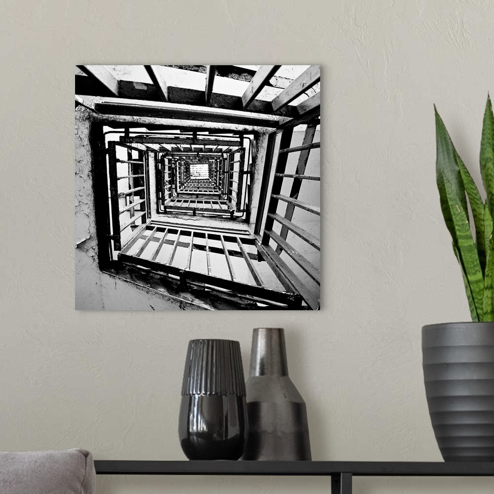 A modern room featuring A monochrome black and white square spiral staircase close-up.