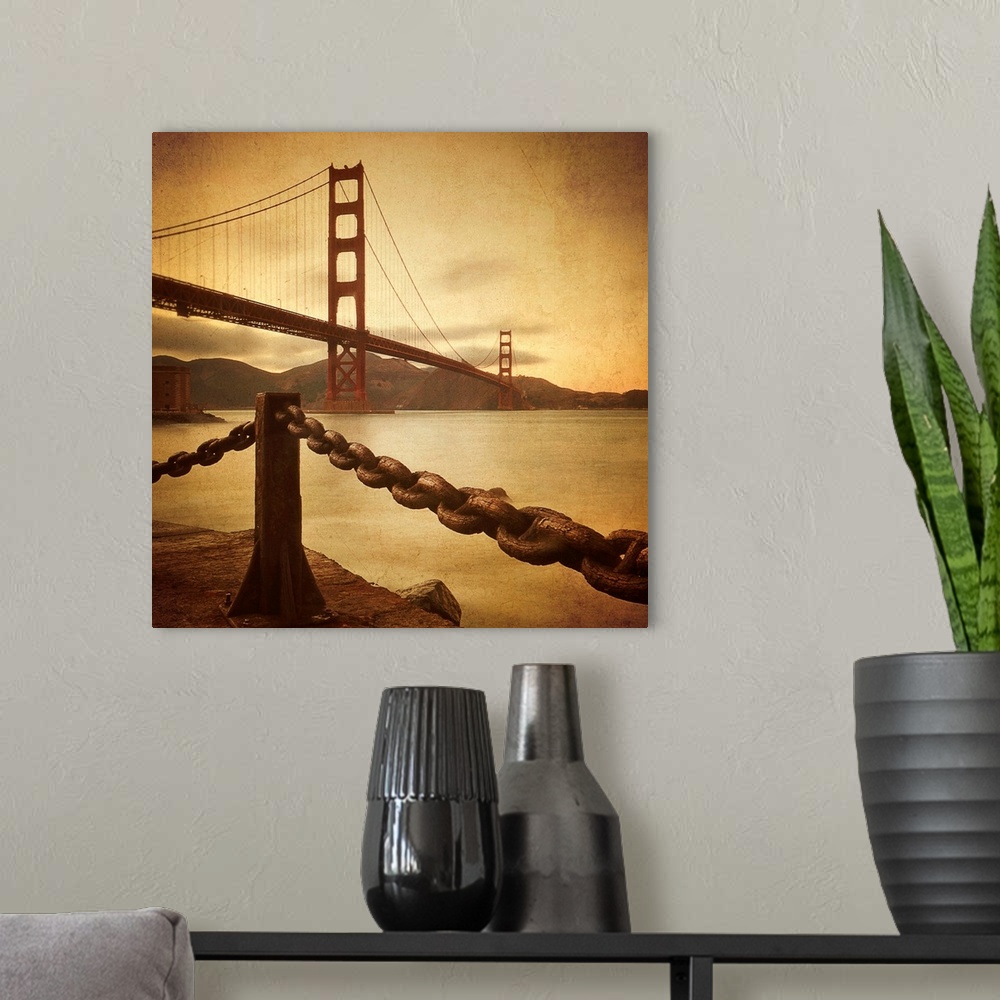 A modern room featuring This large square print is a low angle view of the Golden Gate Bridge from land where there is a ...