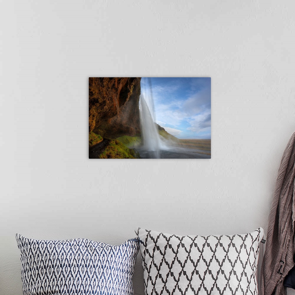 A bohemian room featuring Fine art photograph of a tall waterfall in Iceland.