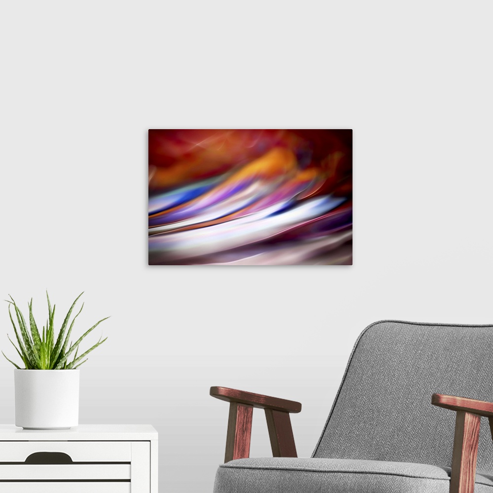 A modern room featuring Abstract photograph in red and white shades resembling ocean waves.