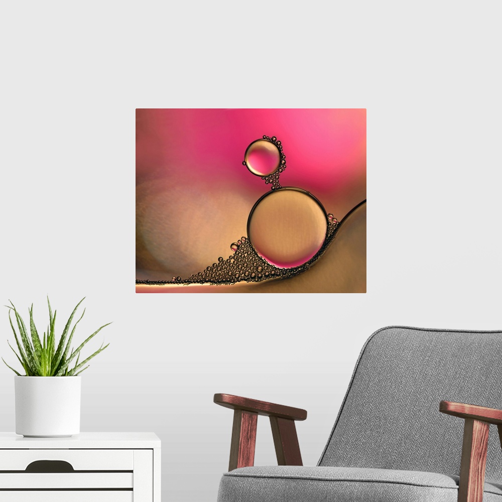 A modern room featuring Macro photograph of drops of oil in water with pink and orange hues.