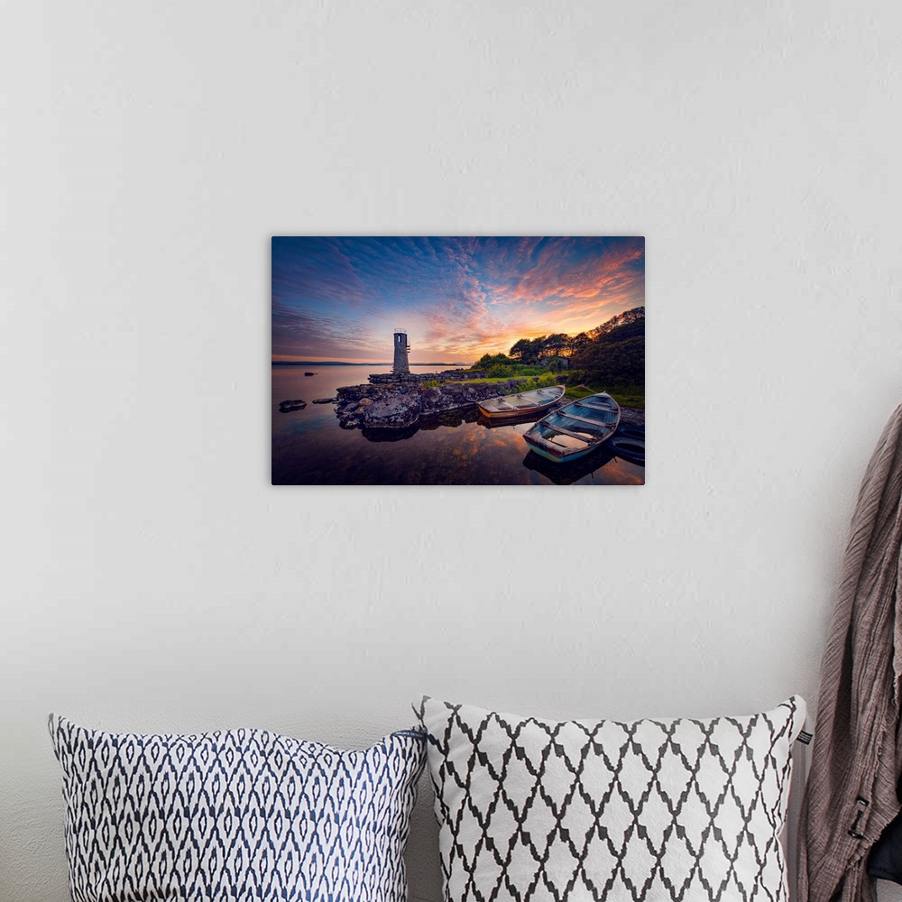 A bohemian room featuring Sunset in Ireland with rowing boats in the foreground around a lighthouse