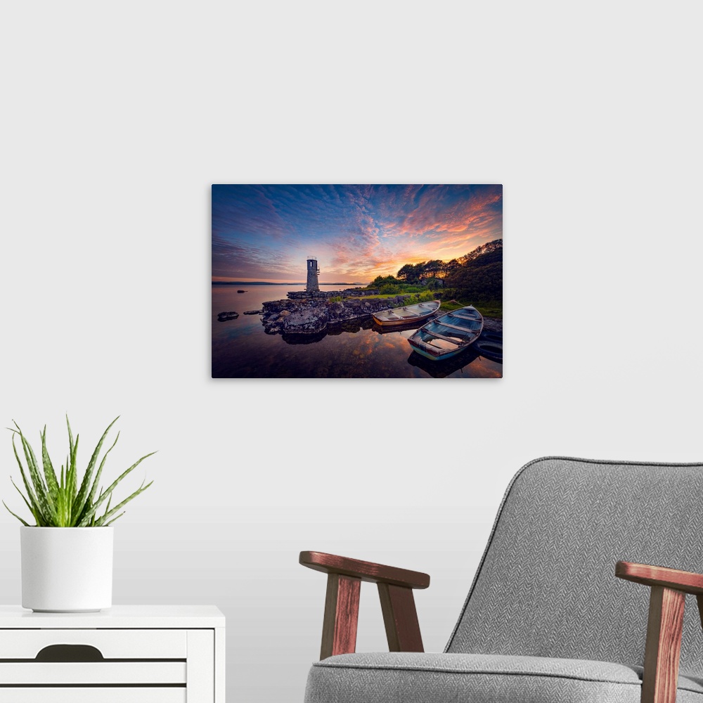 A modern room featuring Sunset in Ireland with rowing boats in the foreground around a lighthouse