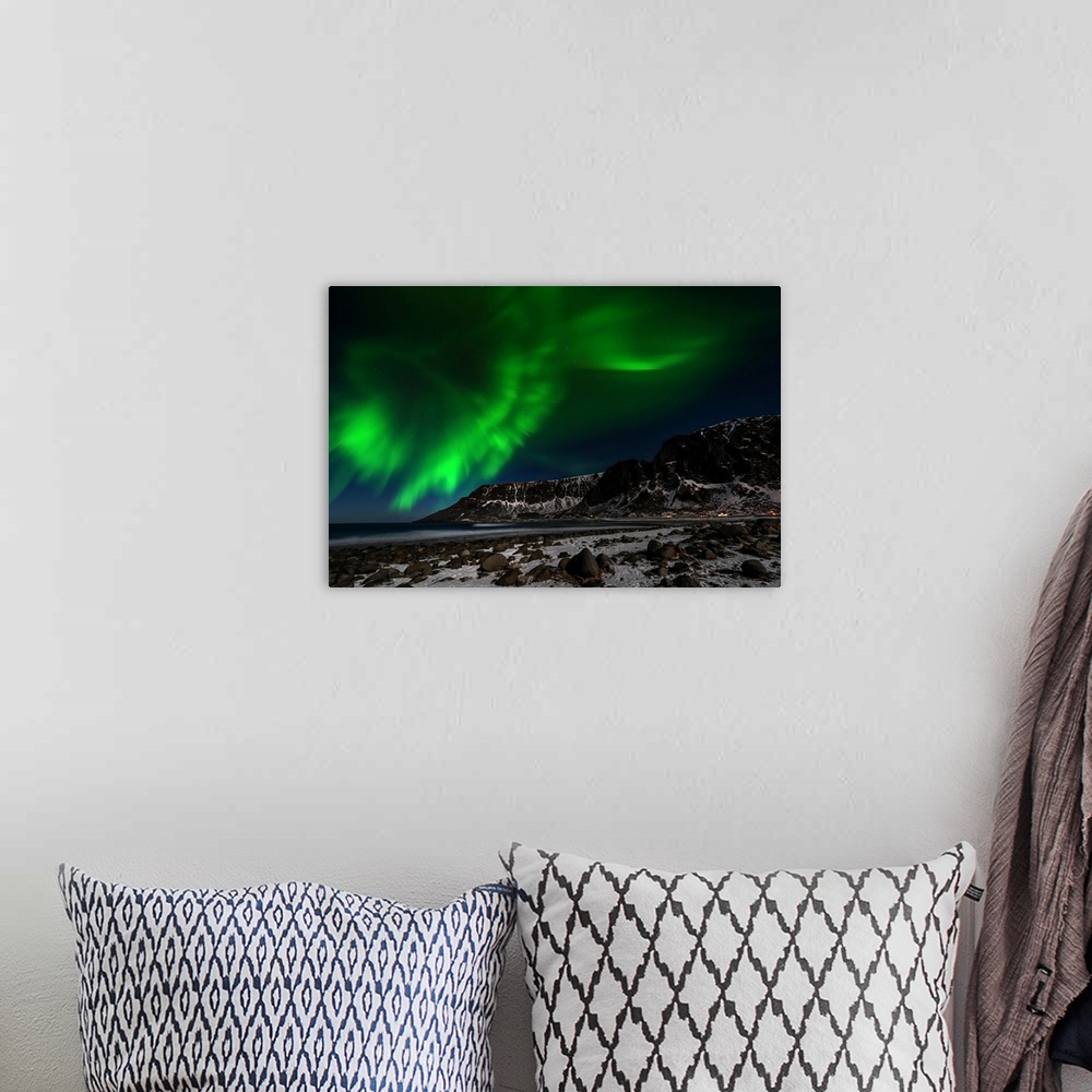 A bohemian room featuring A photograph of the northern lights seen above a rugged winter landscape.