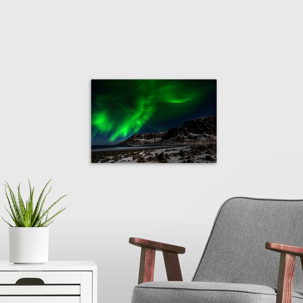 A modern room featuring A photograph of the northern lights seen above a rugged winter landscape.