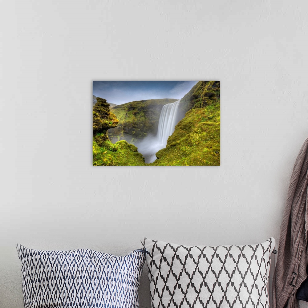 A bohemian room featuring Fine art photograph of a waterfall in Iceland surrounded by mossy rocks.