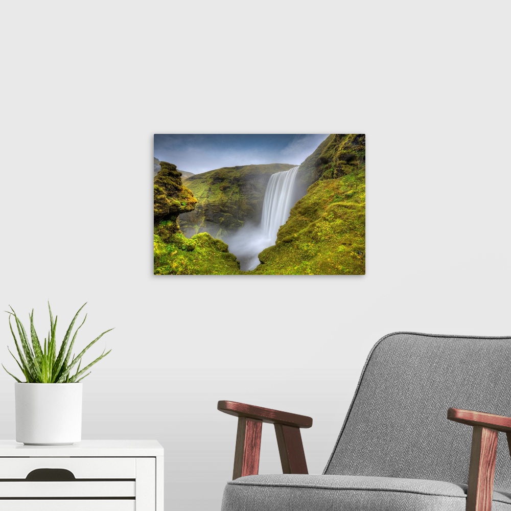A modern room featuring Fine art photograph of a waterfall in Iceland surrounded by mossy rocks.