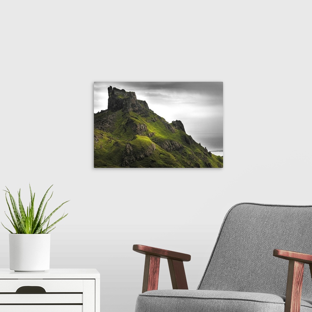 A modern room featuring Fine art photo of rocky spires on a green hill under a cloudy sky.