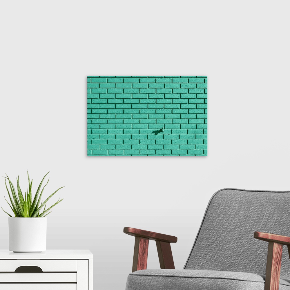 A modern room featuring A faucet sticking out of a teal painted brick wall.