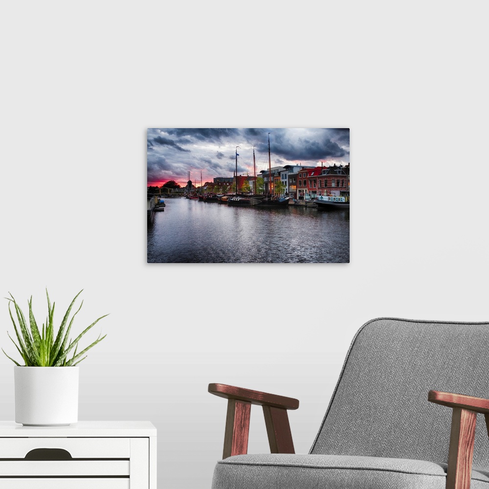 A modern room featuring Canal with old ship, windmill, and a drawbridge at sunset, Leiden, Netherlands.