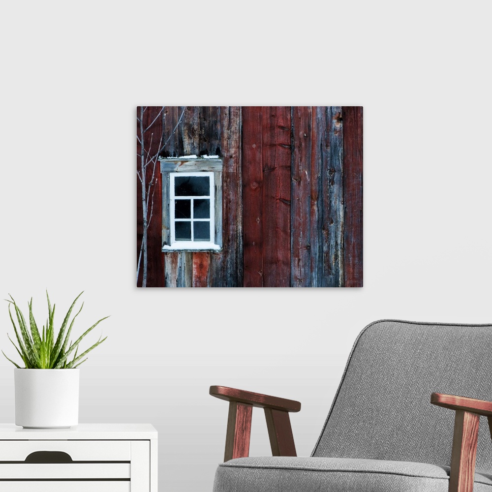 A modern room featuring White window on the side of a weathered red barn.
