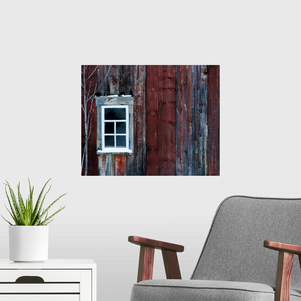 A modern room featuring White window on the side of a weathered red barn.
