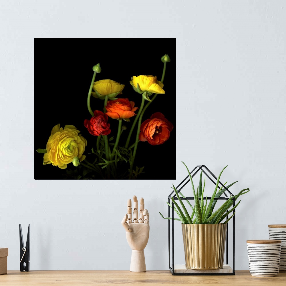 A bohemian room featuring Wall art of a colorful bouquet of beautiful yellow and red flowers and buds.