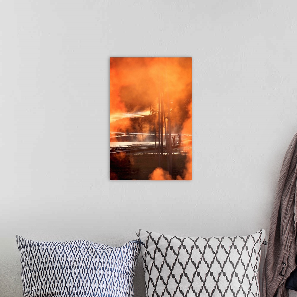 A bohemian room featuring A photo of orange smoke clouds obscuring a view of Yellowstone park and two patrons.