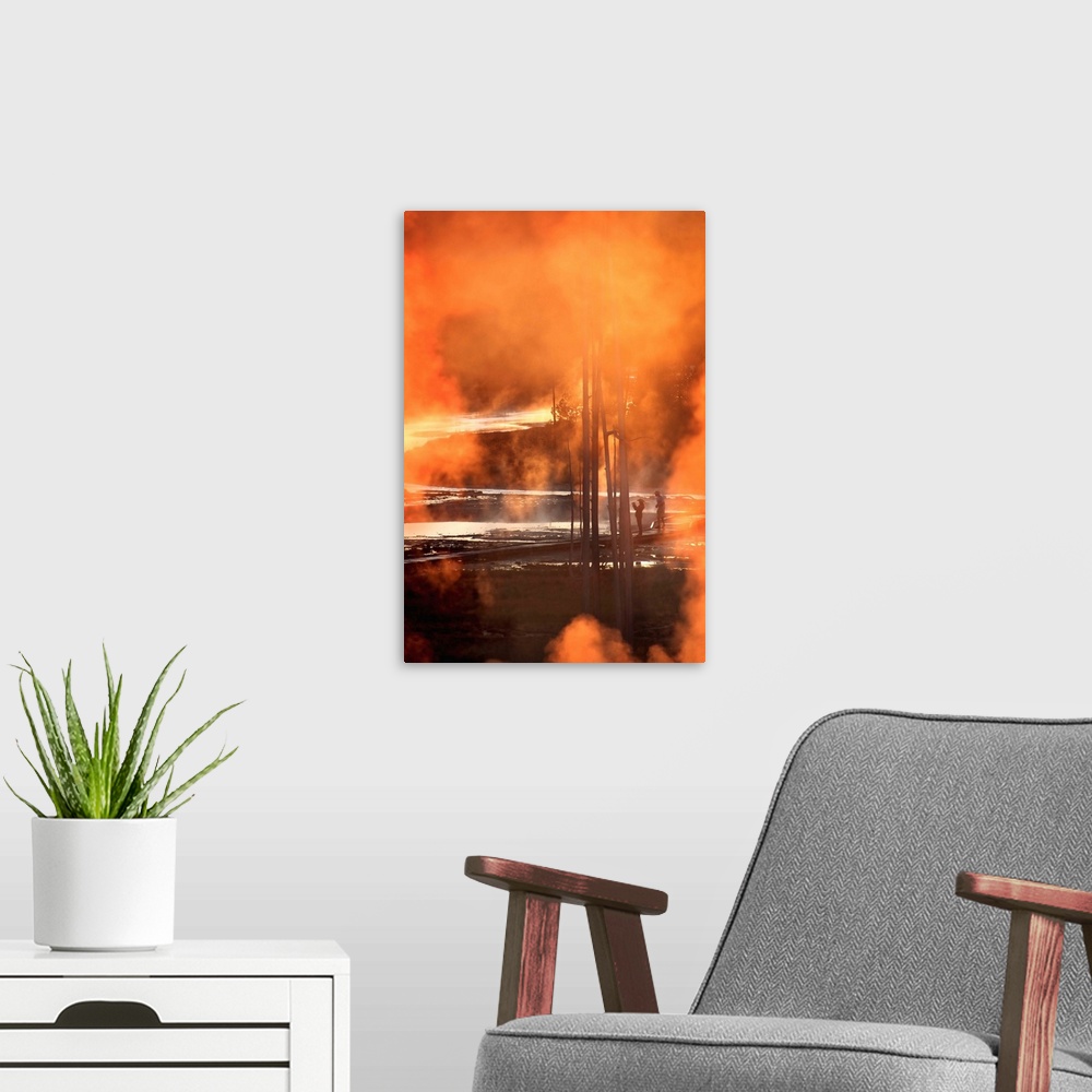 A modern room featuring A photo of orange smoke clouds obscuring a view of Yellowstone park and two patrons.