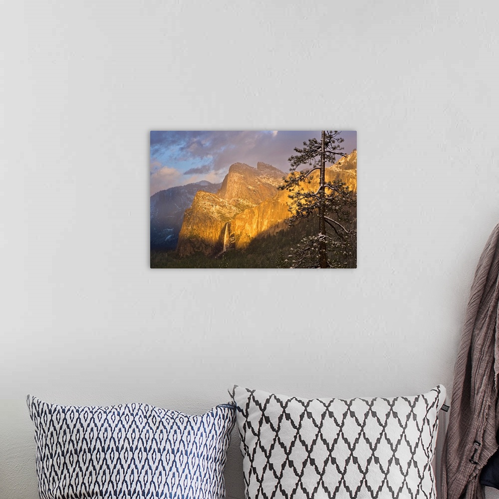 A bohemian room featuring Large canvas photo print of big rugged mountains with a waterfall highlighted with the warm color...