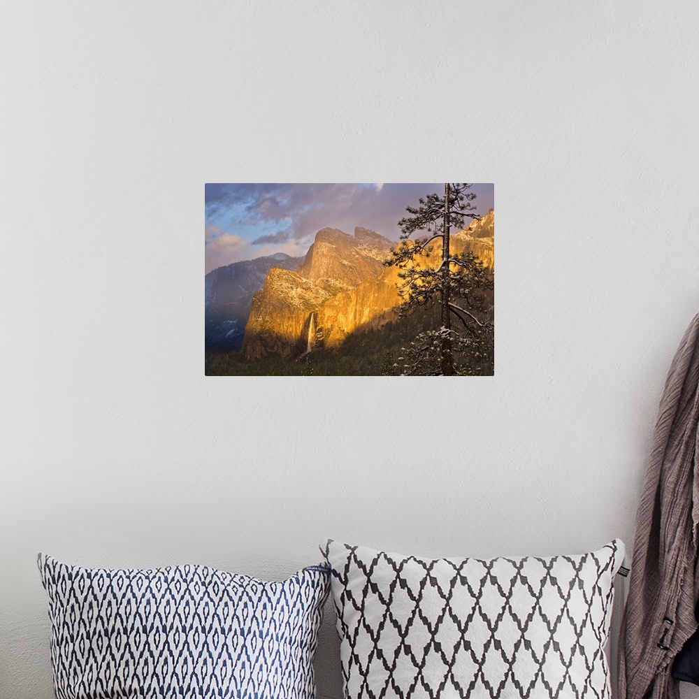 A bohemian room featuring Large canvas photo print of big rugged mountains with a waterfall highlighted with the warm color...