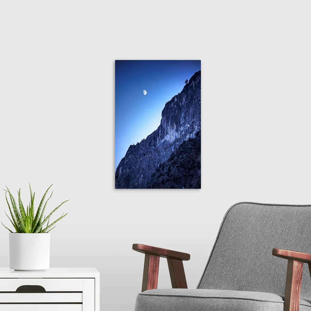 A modern room featuring The moon in the sky over the side of a mountain in Yosemite National Park, California.