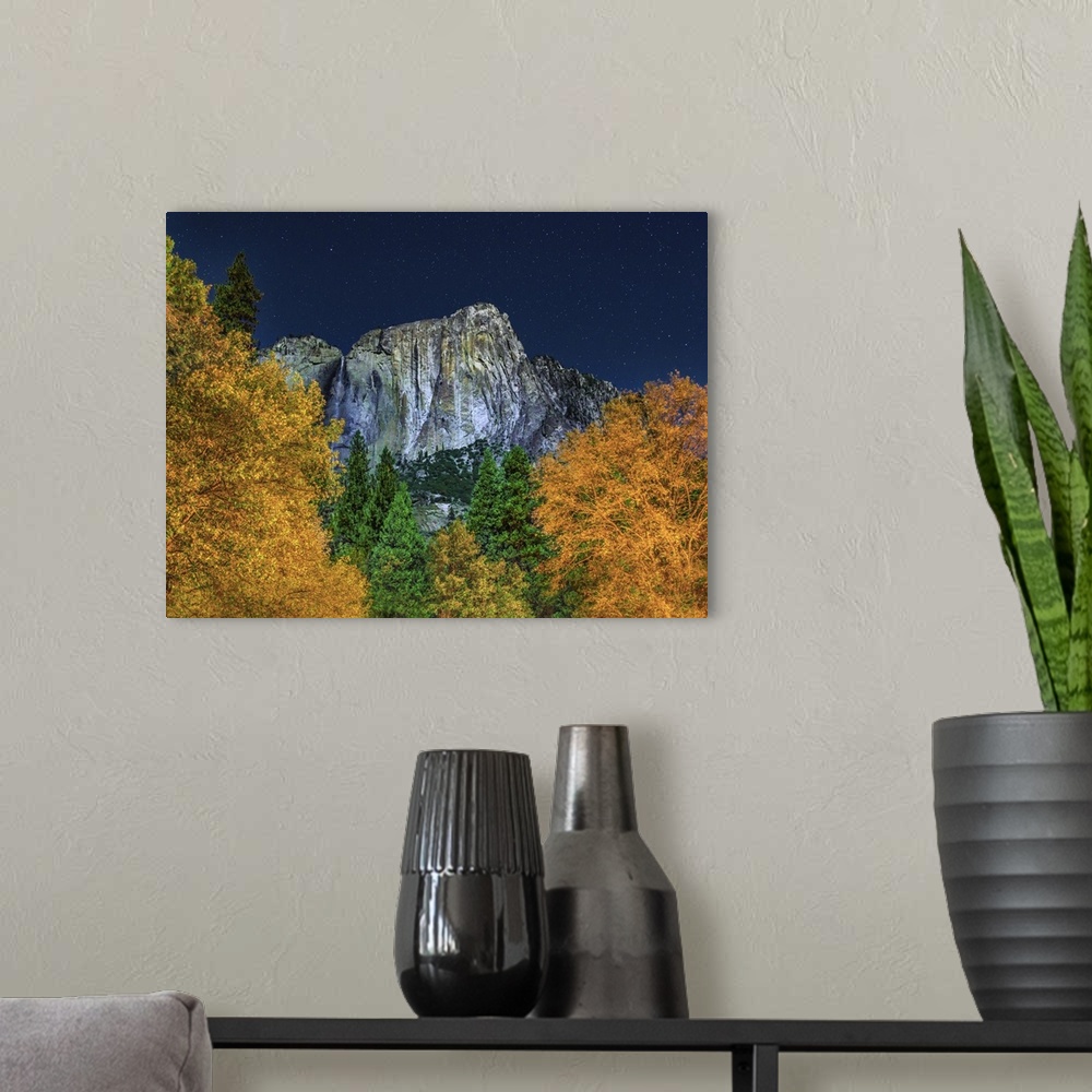 A modern room featuring Half Dome seen over the forest canopy under the starry night sky, Yosemite, California.