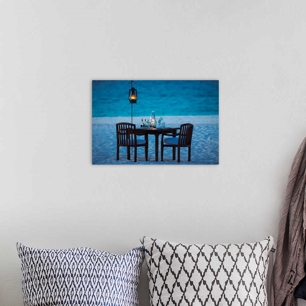 A bohemian room featuring A photograph of a romantic table setting on a sandy beach at sunset.