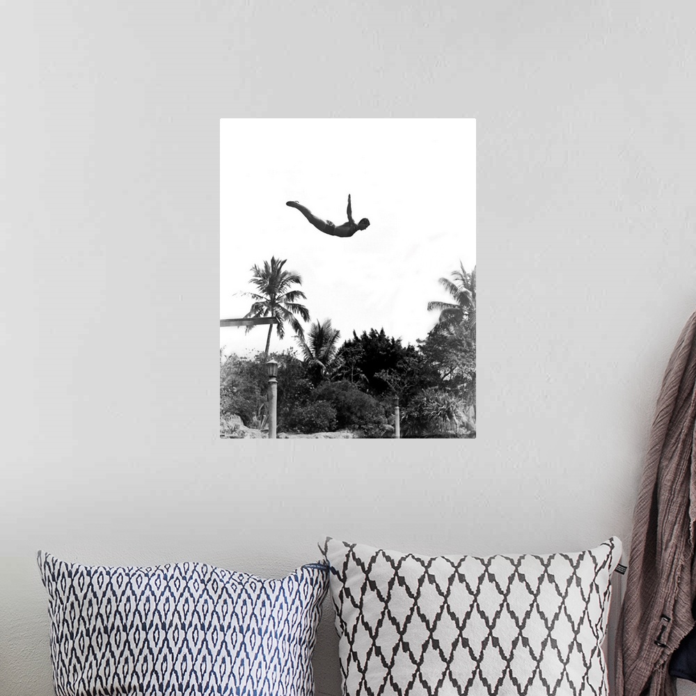 A bohemian room featuring 1940's Man Poised Midair Jumping From Diving Board Into Pool