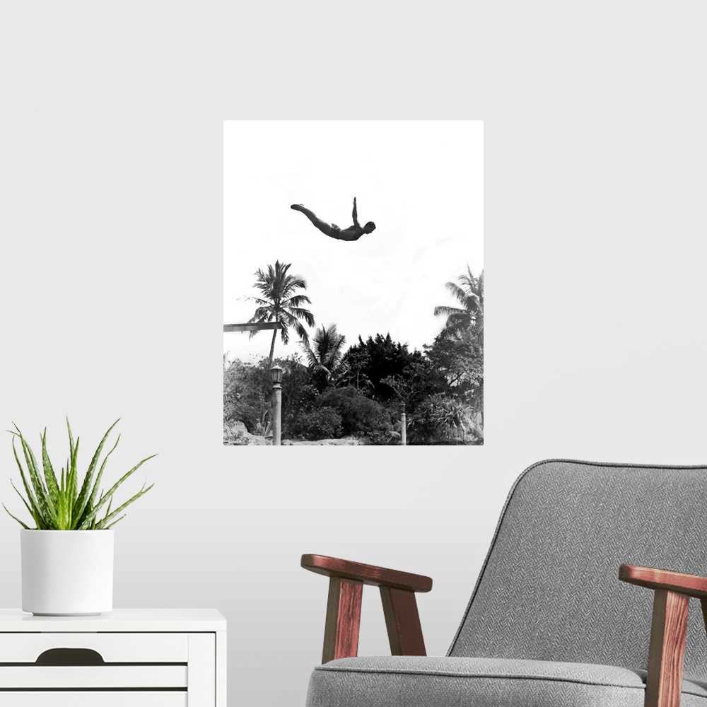 A modern room featuring 1940's Man Poised Midair Jumping From Diving Board Into Pool