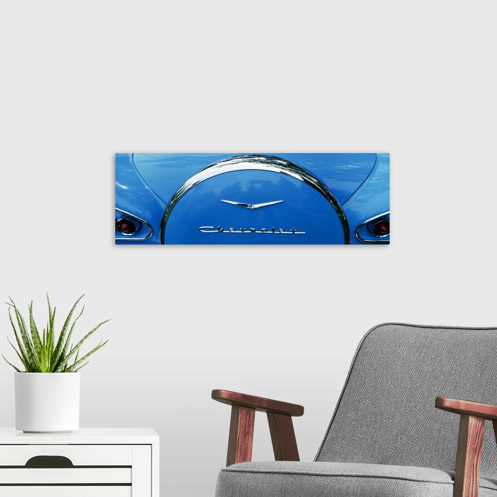 A modern room featuring Oversized, landscape photograph of the back end of a shiny blue 1958 Chevrolet Bel-Air, including...