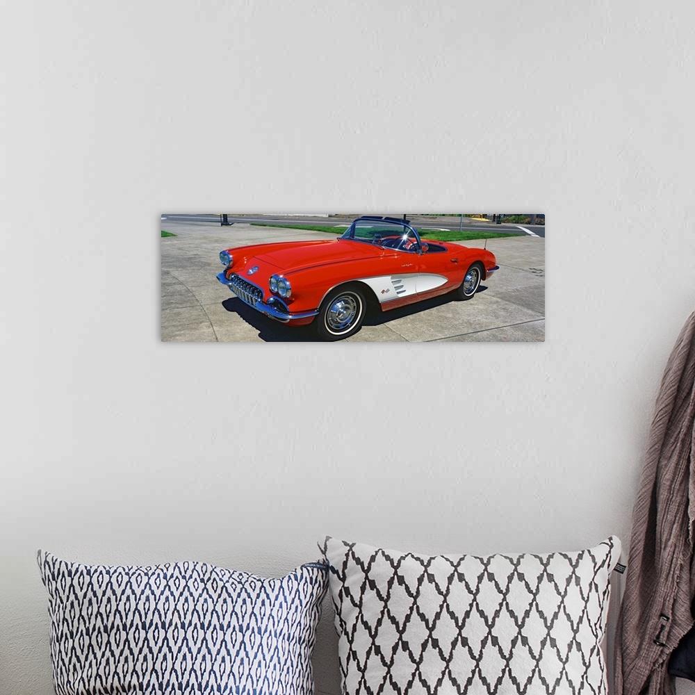 A bohemian room featuring This panoramic photograph shows a vintage muscle car convertible parked on pavement.
