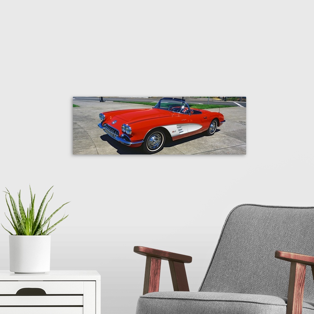 A modern room featuring This panoramic photograph shows a vintage muscle car convertible parked on pavement.