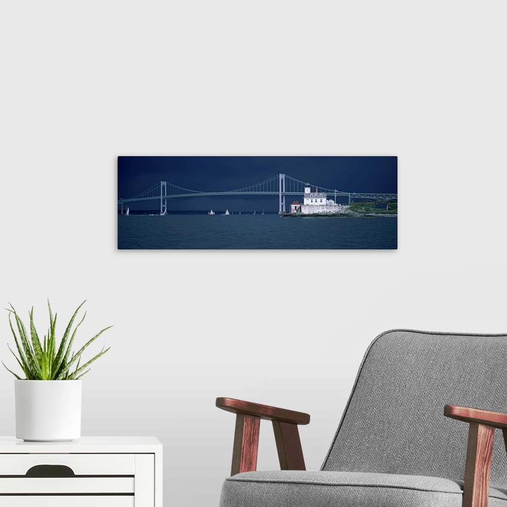 A modern room featuring A storm approaches sailboats racing past Rose Island lighthouse and the Newport Bridge in Narraga...