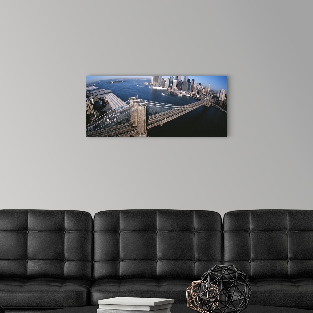 A modern room featuring Panorama of the Brooklyn Bridge, skyscrapers and boats in the East River of New York City.