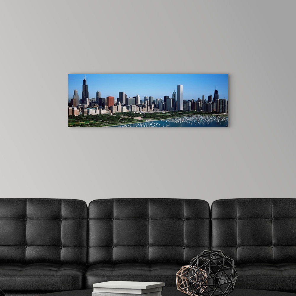 A modern room featuring This panoramic photograph shows the city skyline and a crowded harbor on the lake on a sunny clou...