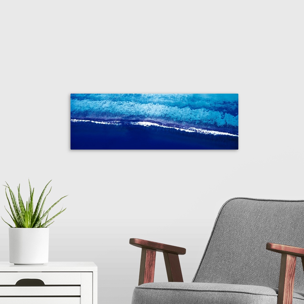 A modern room featuring This is a panoramic photograph taken from above of waves breaking on the shore of this tropical r...