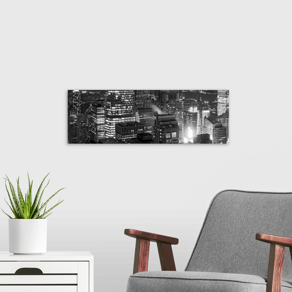 A modern room featuring Panoramic photograph of lit up buildings in the "Big Apple."
