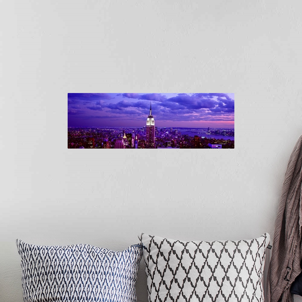 A bohemian room featuring This is a large aerial photograph taken of NYC at dusk with all of the buildings lit and the empi...