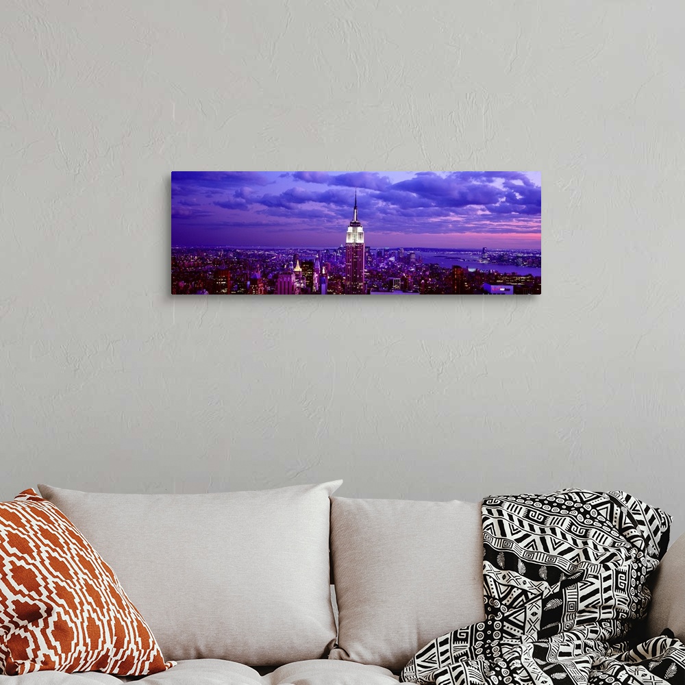 A bohemian room featuring This is a large aerial photograph taken of NYC at dusk with all of the buildings lit and the empi...